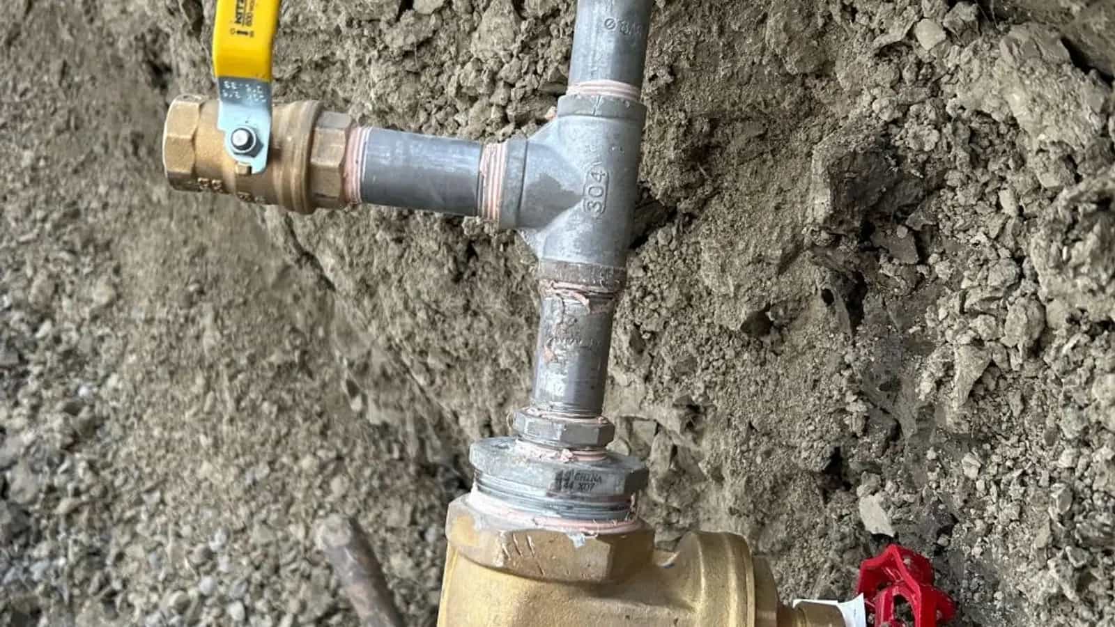 Buried gas-line pressure-test assembly with gauge and shut-off valves in an open trench