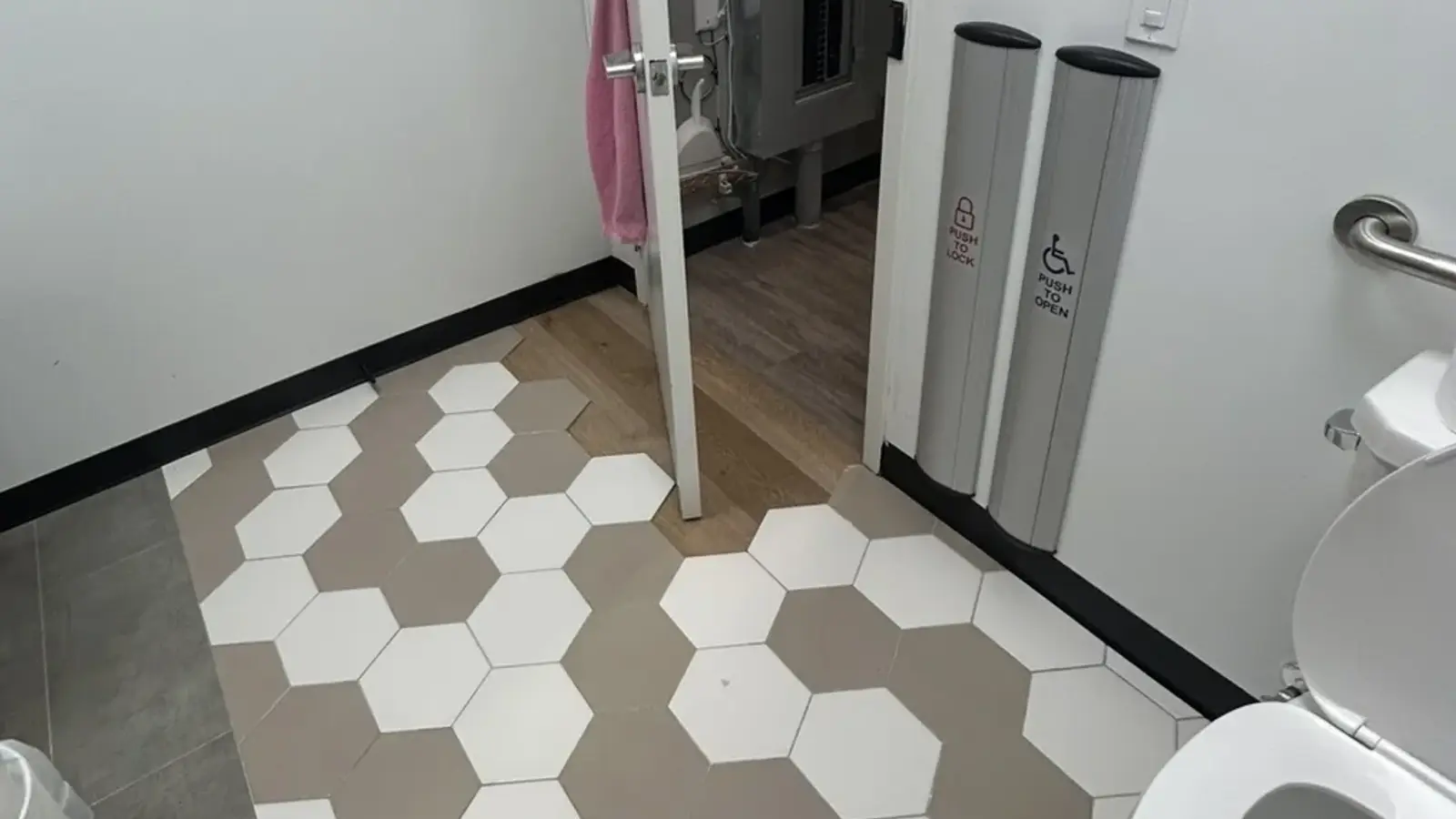 Finished accessible washroom with hex-tile feature floor, grab bars and push-to-open hardware