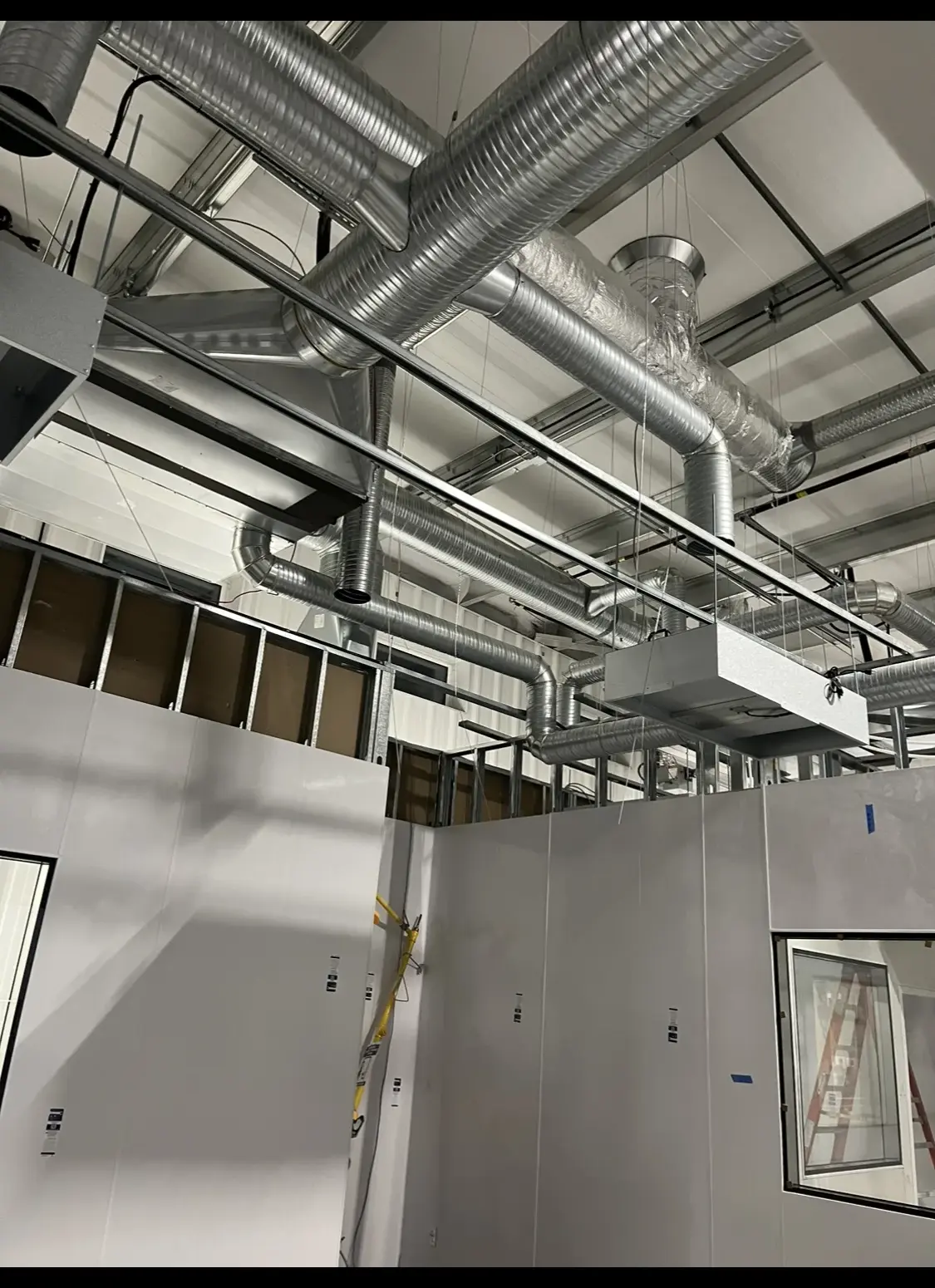 Insulated flex and spiral duct network above panel-built cleanrooms