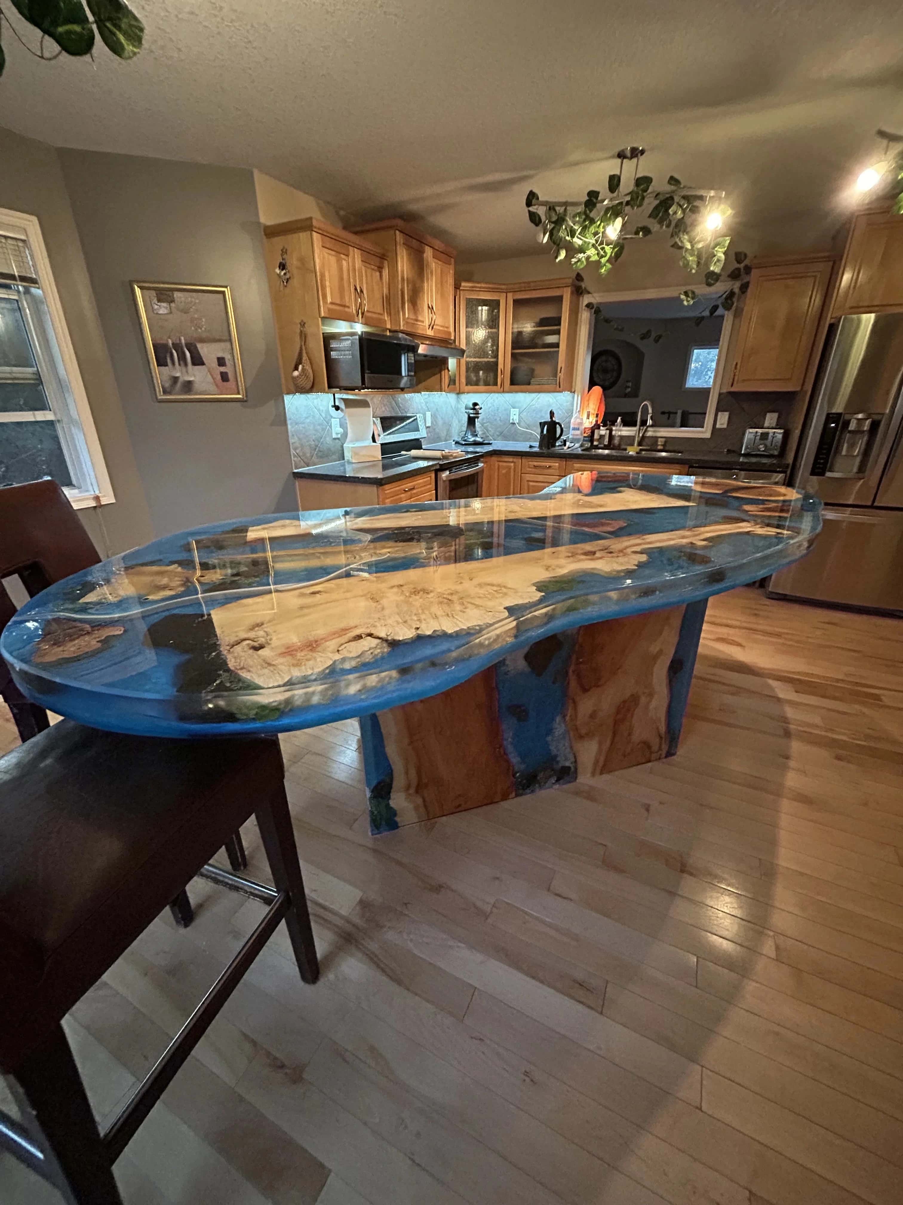 Live-edge island with a blue epoxy river top anchoring a family kitchen